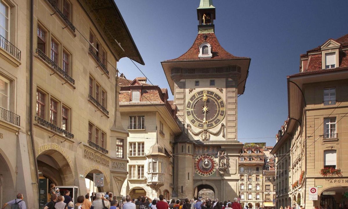 Un edificio con una torre de reloj con una multitud de personas.