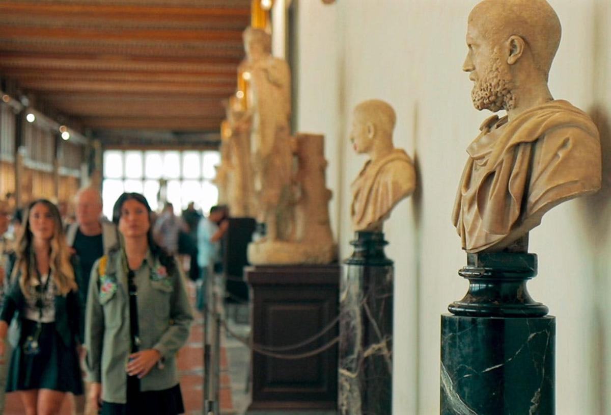 un gruppo di persone che guarda una statua in un museo