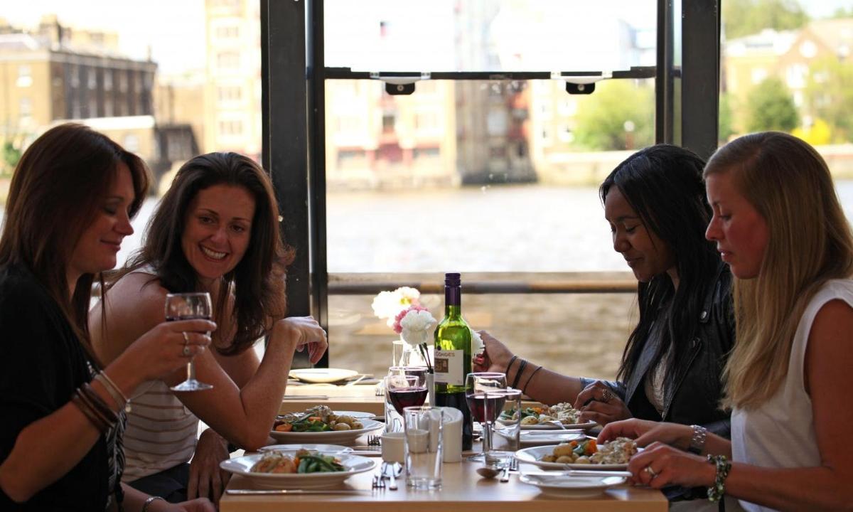 a group of women sitting at a table eating food