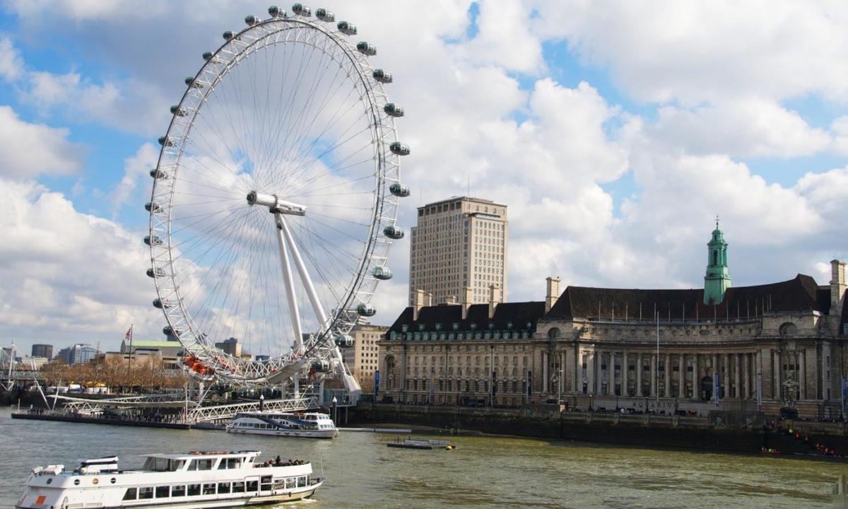 a large ferris wheel on the water in a city