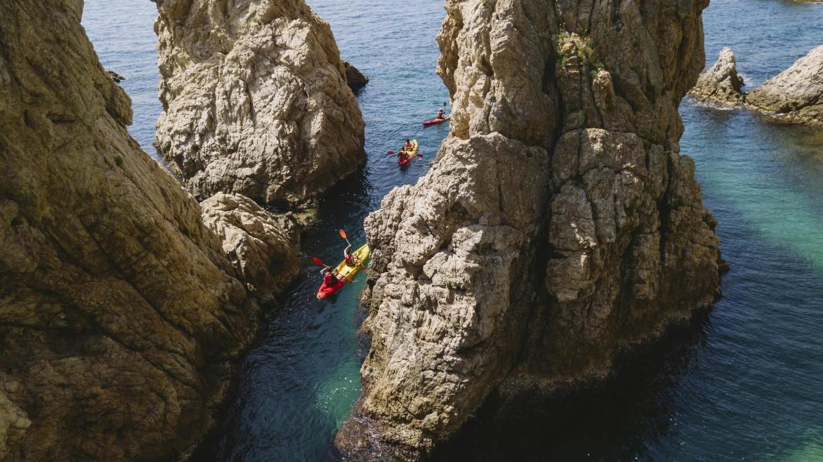 un gruppo di persone che fa kayak nell'acqua tra due scogliere