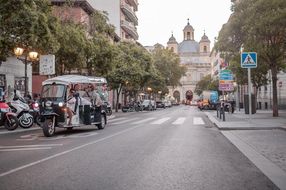 an old car driving down a city street