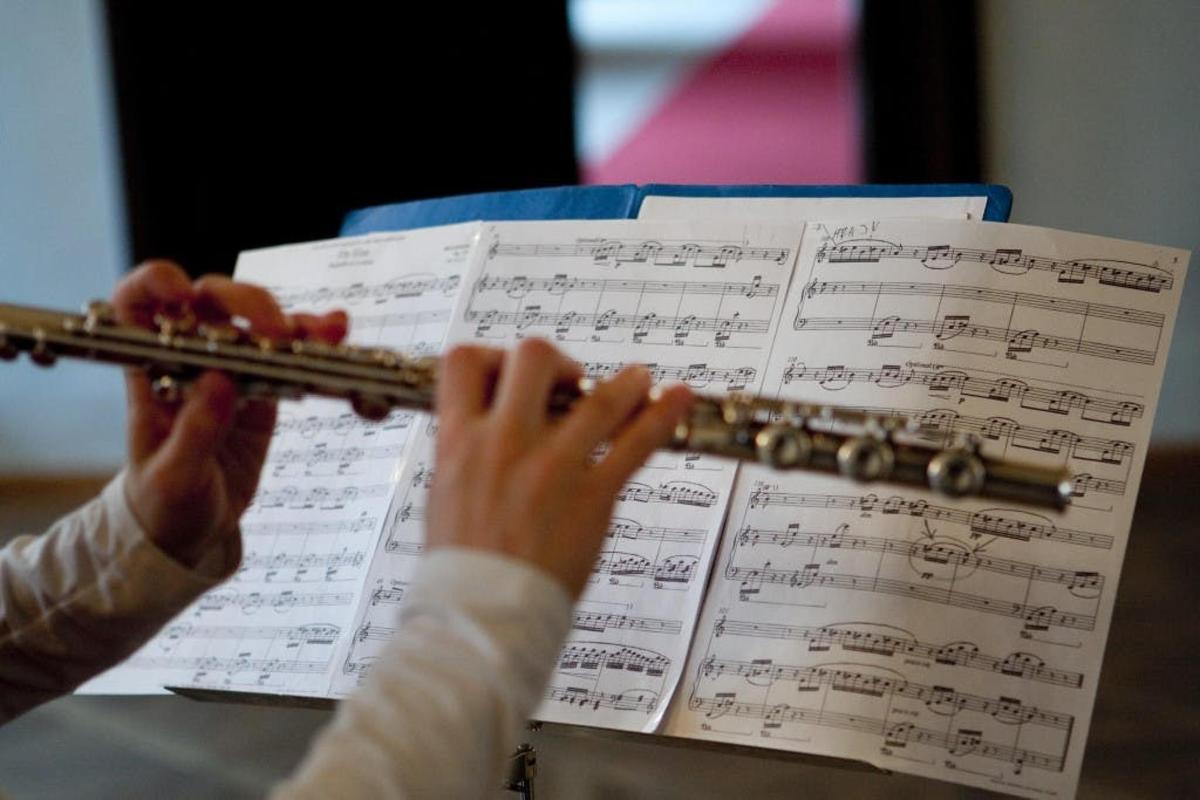 una persona tocant una flauta en una partitura