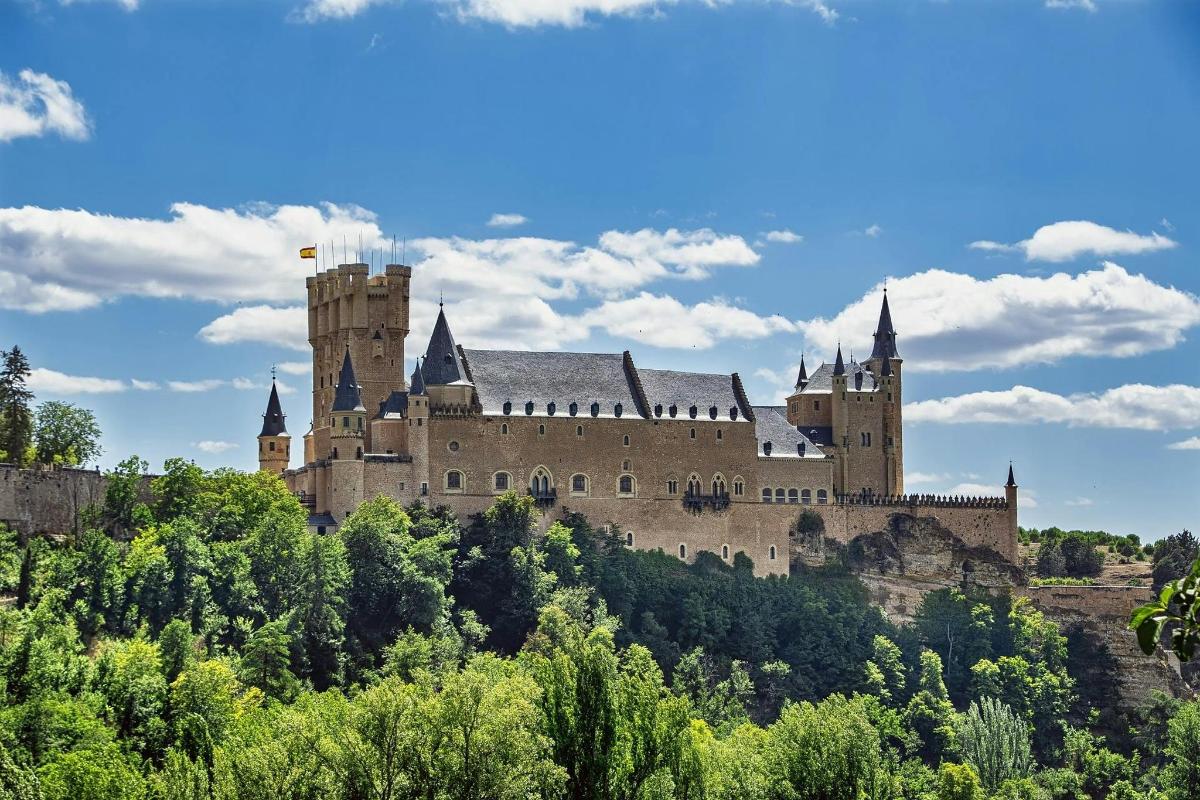 un castell al cim d'un turó amb arbres