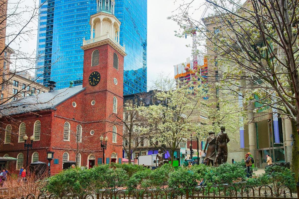 Un edificio de ladrillo con una torre de reloj en una ciudad.