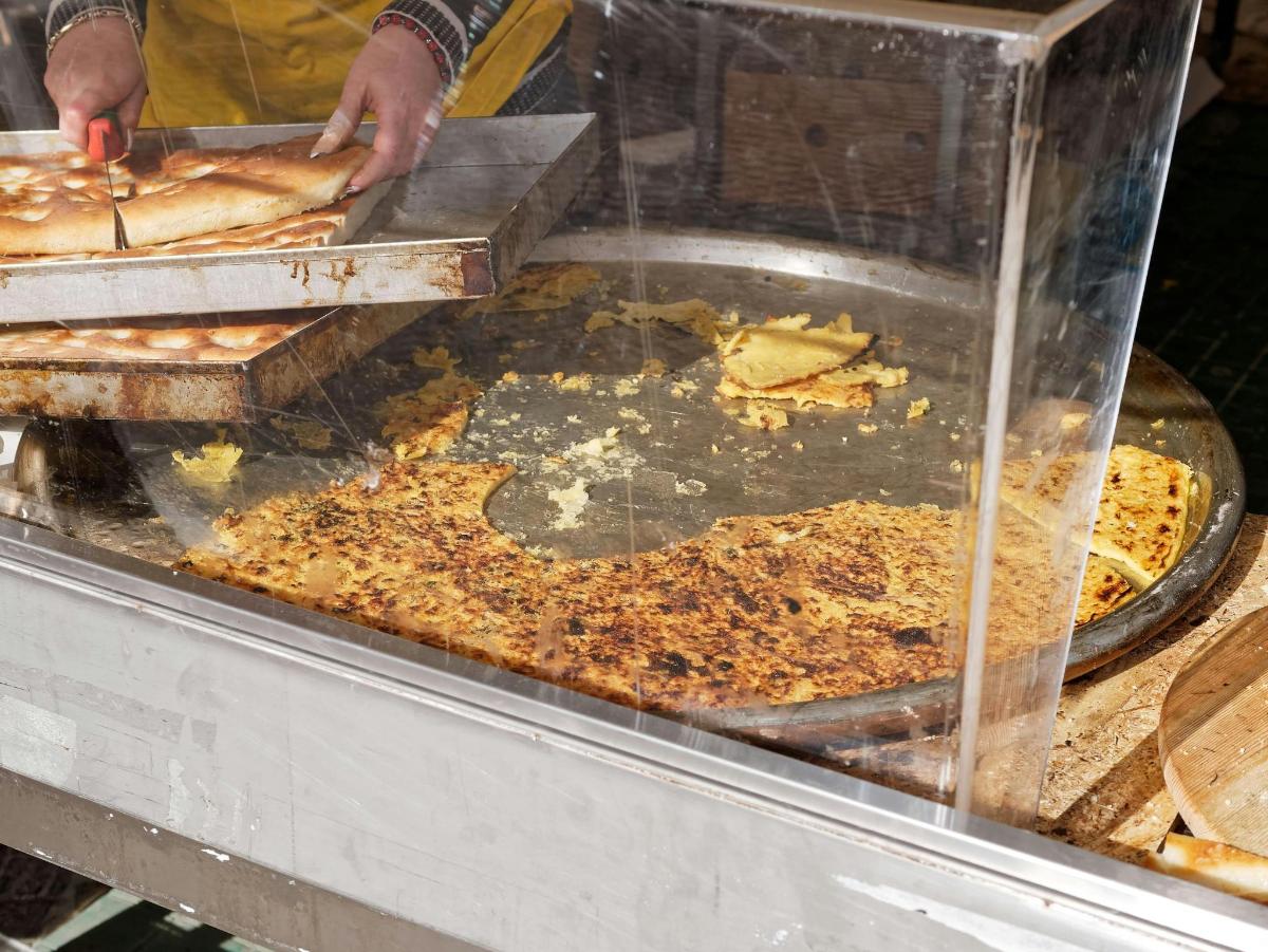 Maður er að búa til pizzur í hlaðborði
