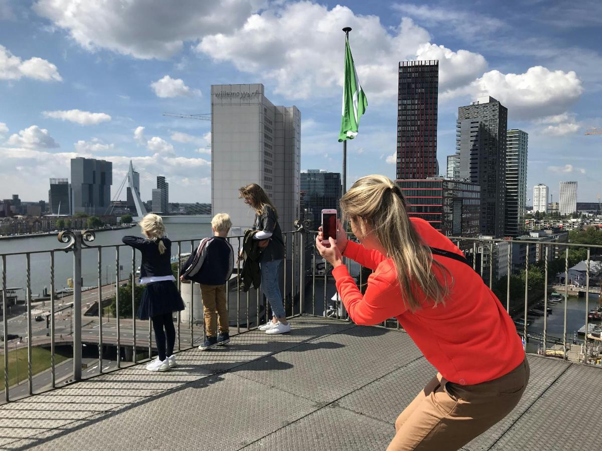 жінка фотографує групу людей на мосту