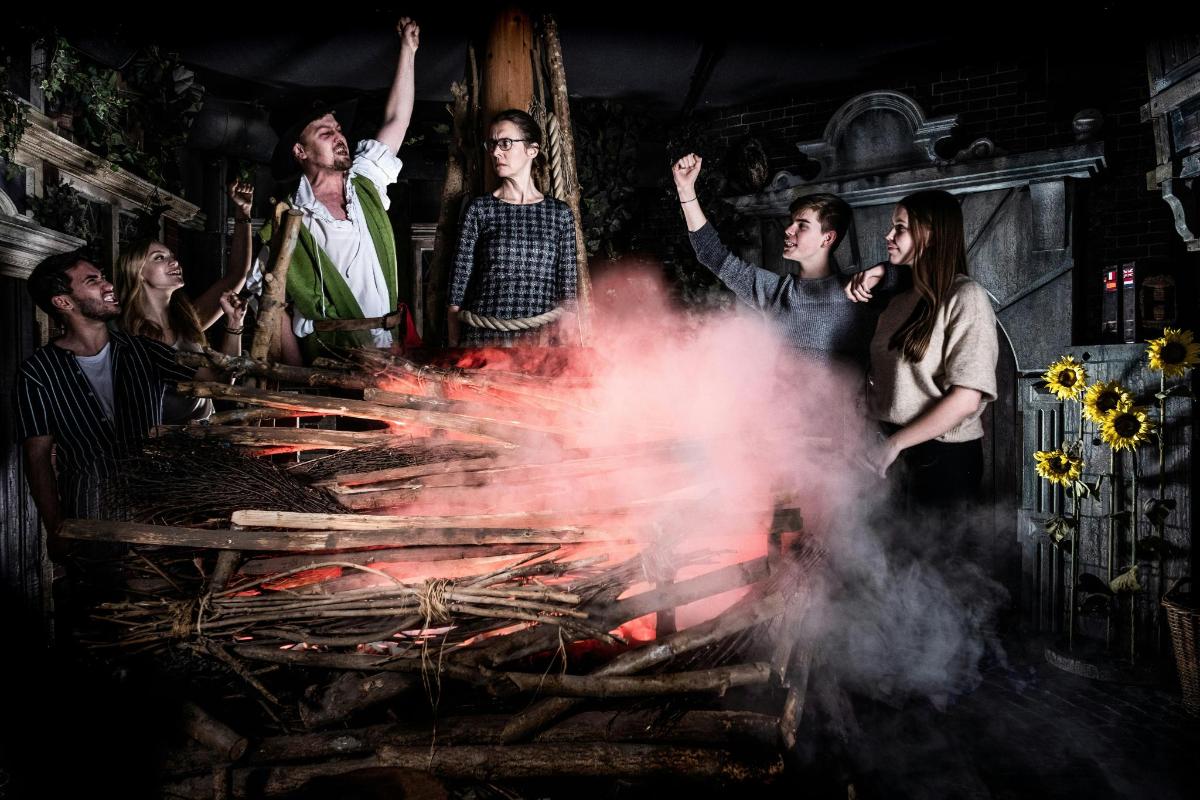 a group of people standing around a large grill