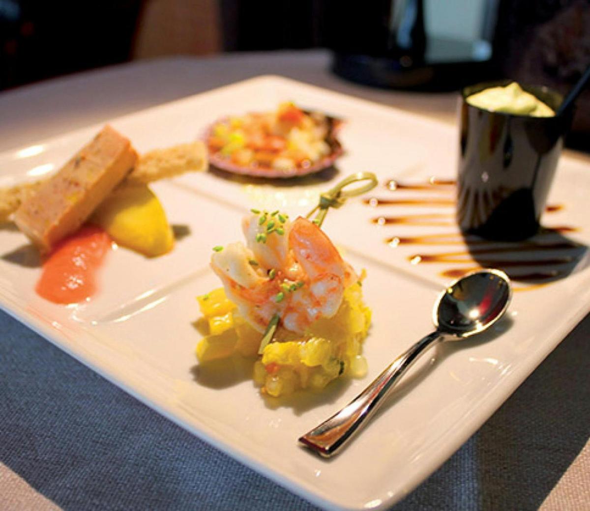 a plate with shrimp and other food on a table