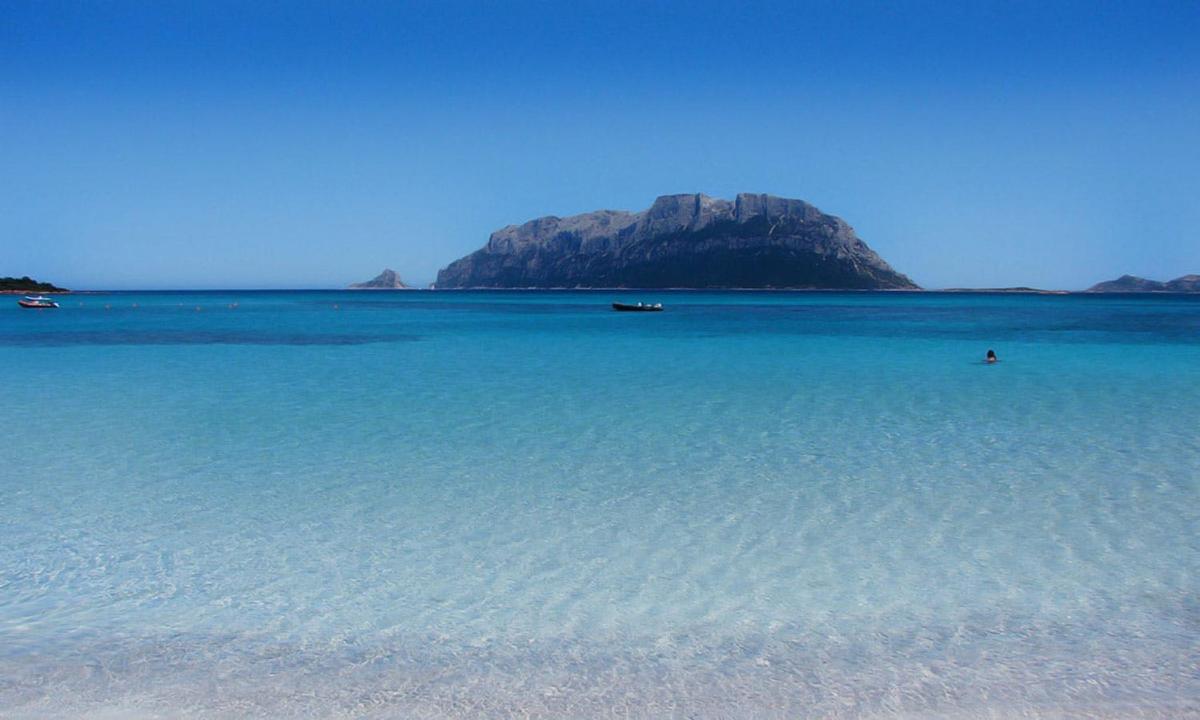 un grande specchio d'acqua con una montagna sullo sfondo