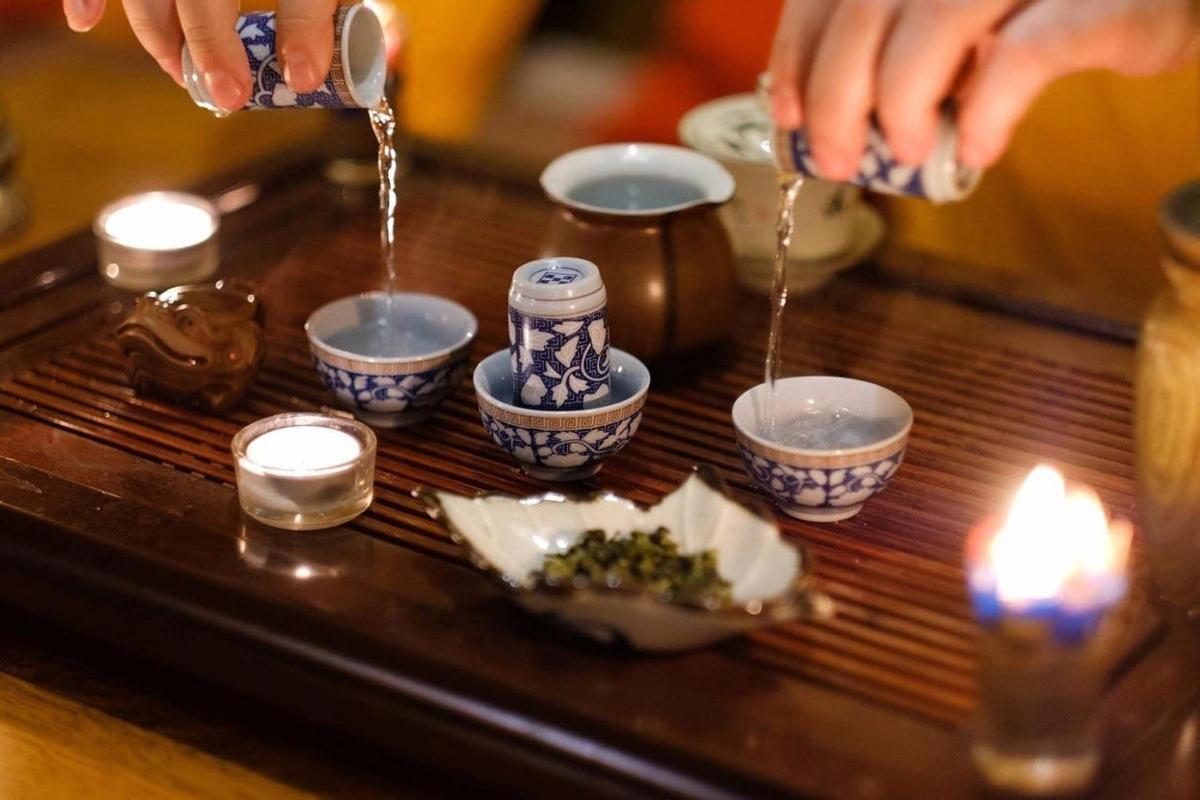 một người đang đổ thức ăn vào bát trên bàn