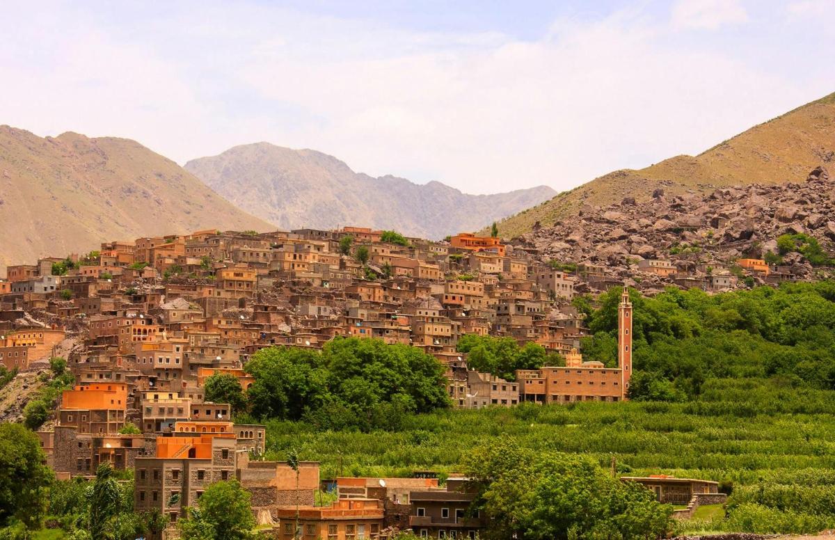 un villaggio su una collina con le montagne sullo sfondo