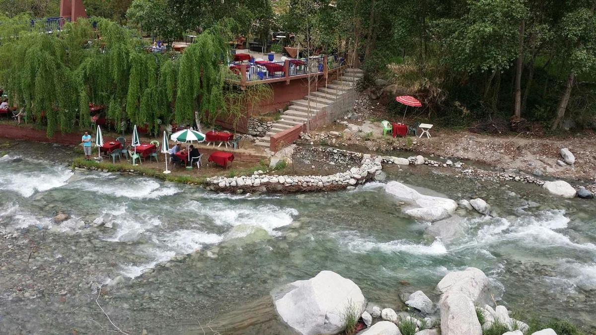 un fiume con un gruppo di tavoli e sedie accanto a un fiume