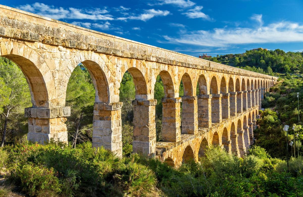 uma velha ponte de pedra com arcos em uma colina