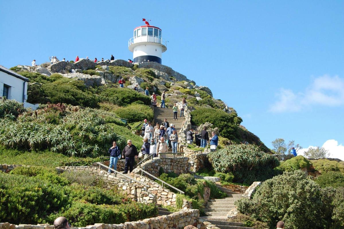 um grupo de pessoas subindo as escadas em direção ao farol