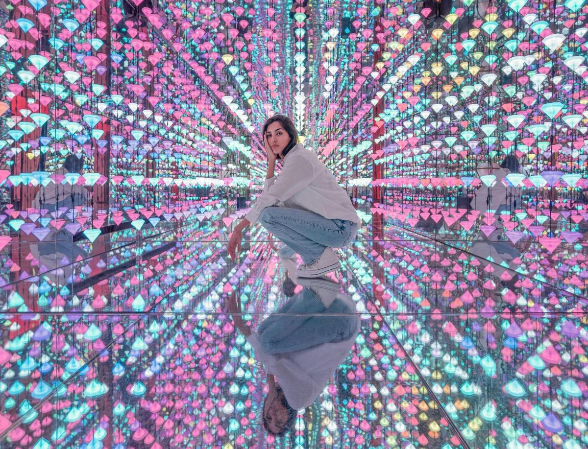 a woman is sitting in front of a wall of lights