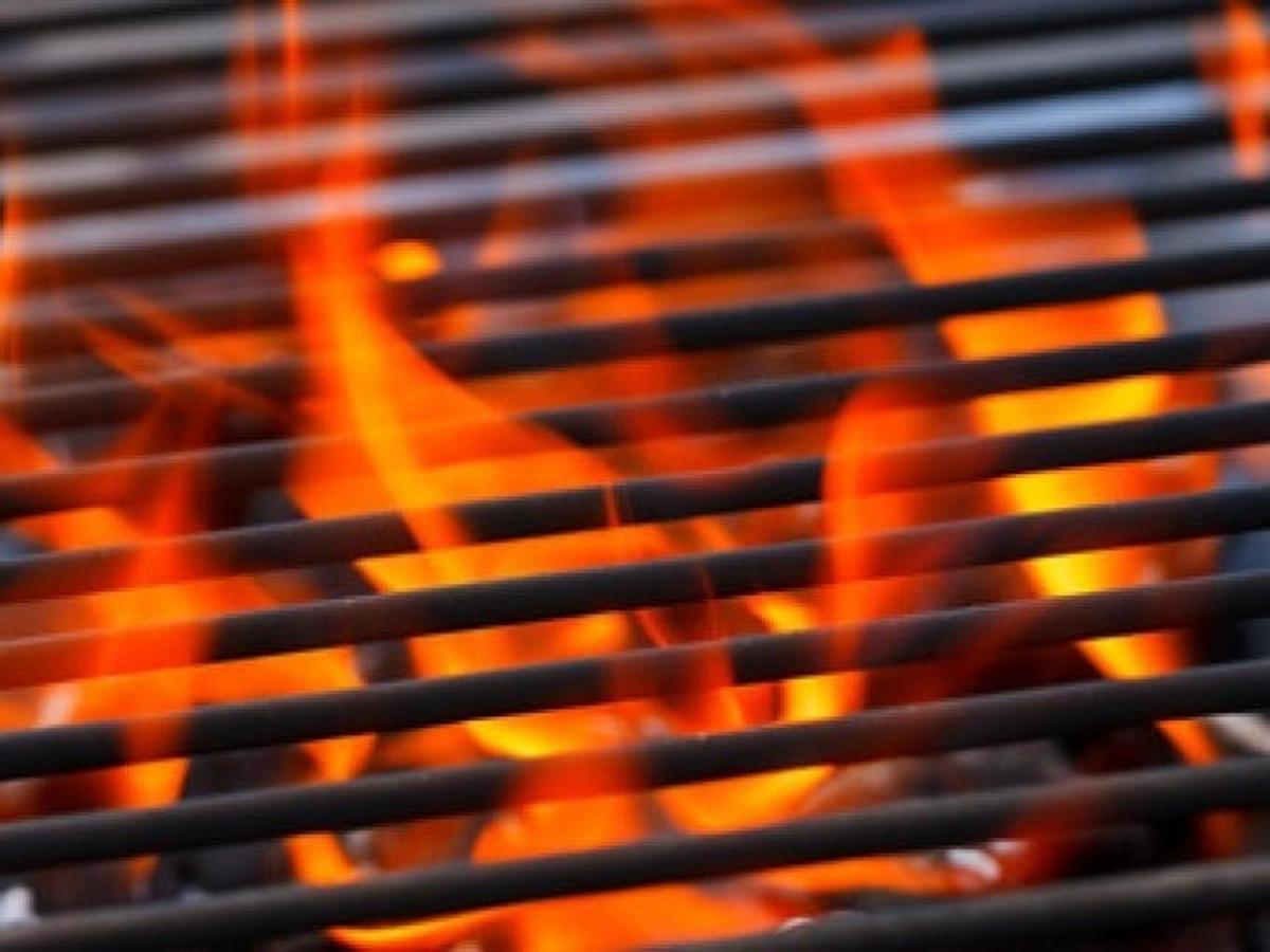 egy közeli kép egy narancssárga lángokkal teli grillsütőről