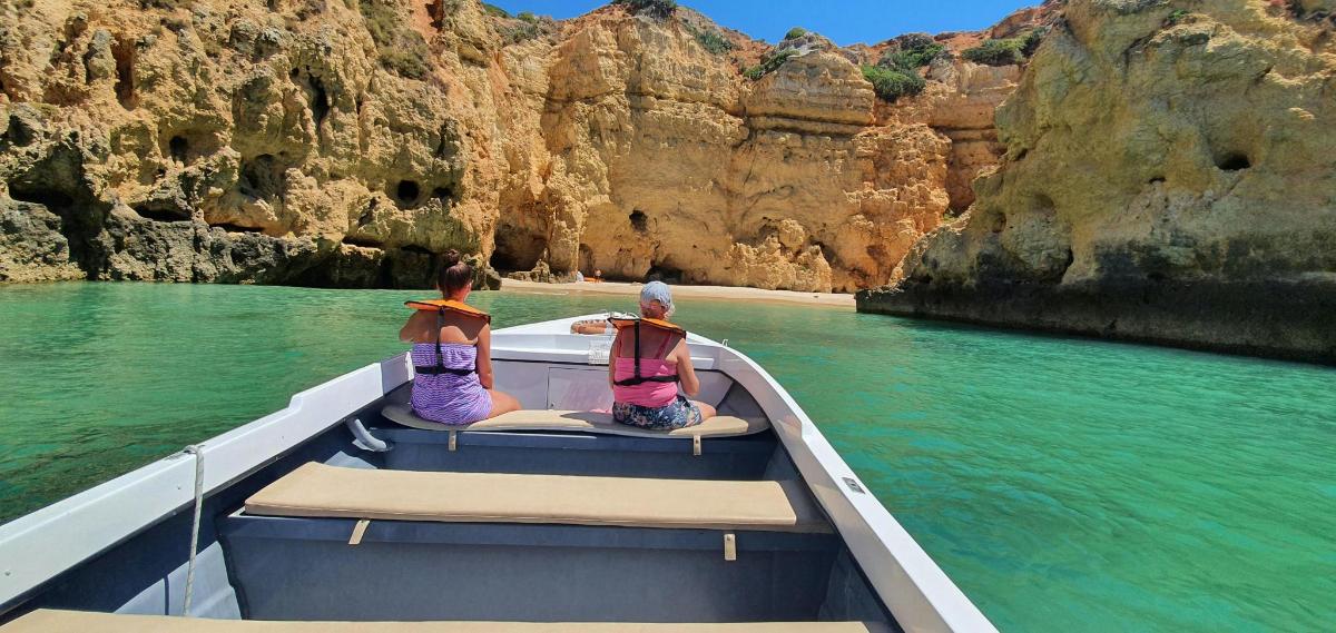 two people sitting on the back of a boat in the water