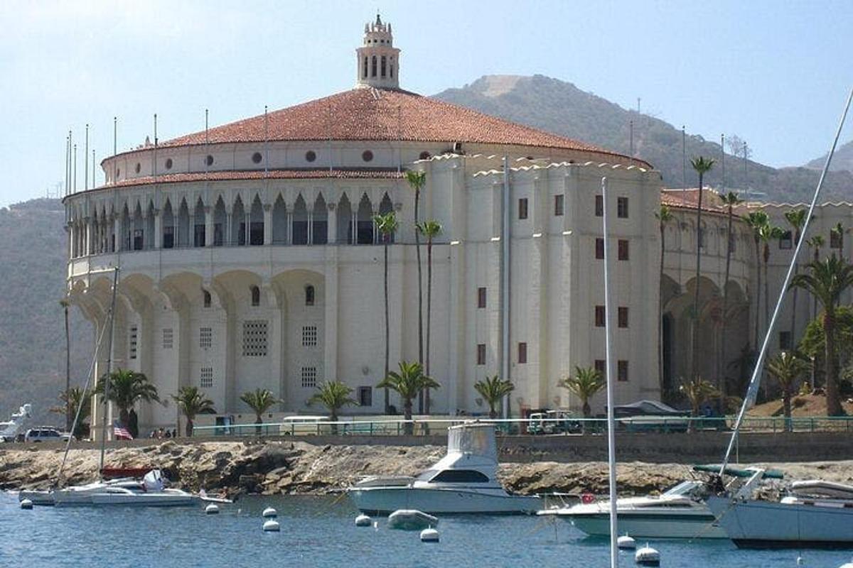 Un gran edificio con barcos en el agua en frente.