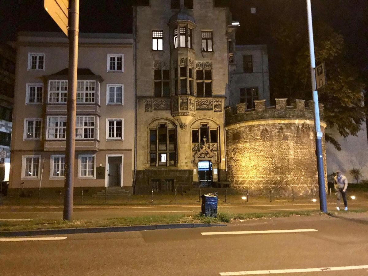 stara stavba ponoči z osebo, ki hodi pred njo
