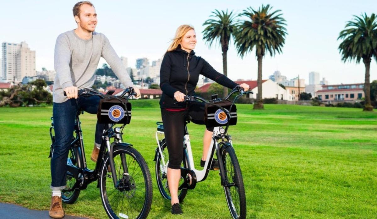 un home i una dona anant en bicicleta en un parc