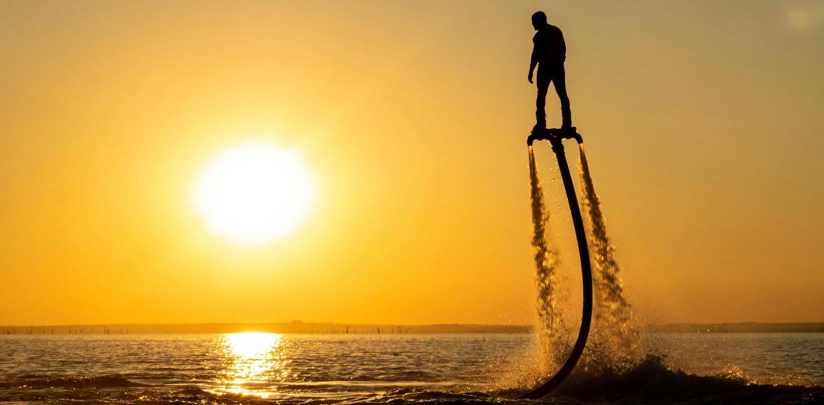 Un hombre parado en lo alto de una torre en el agua.
