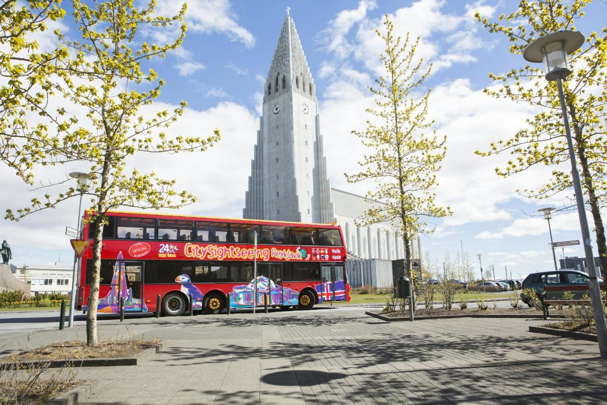 um ônibus vermelho de dois andares estacionado em frente a um prédio
