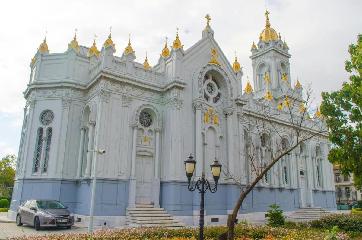 a white cathedral with a car parked in front of it