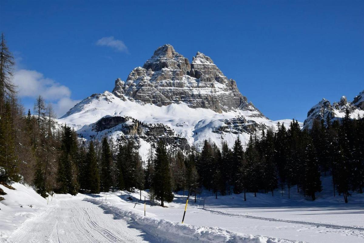 ein schneebedeckter Berg mit einer Straße davor
