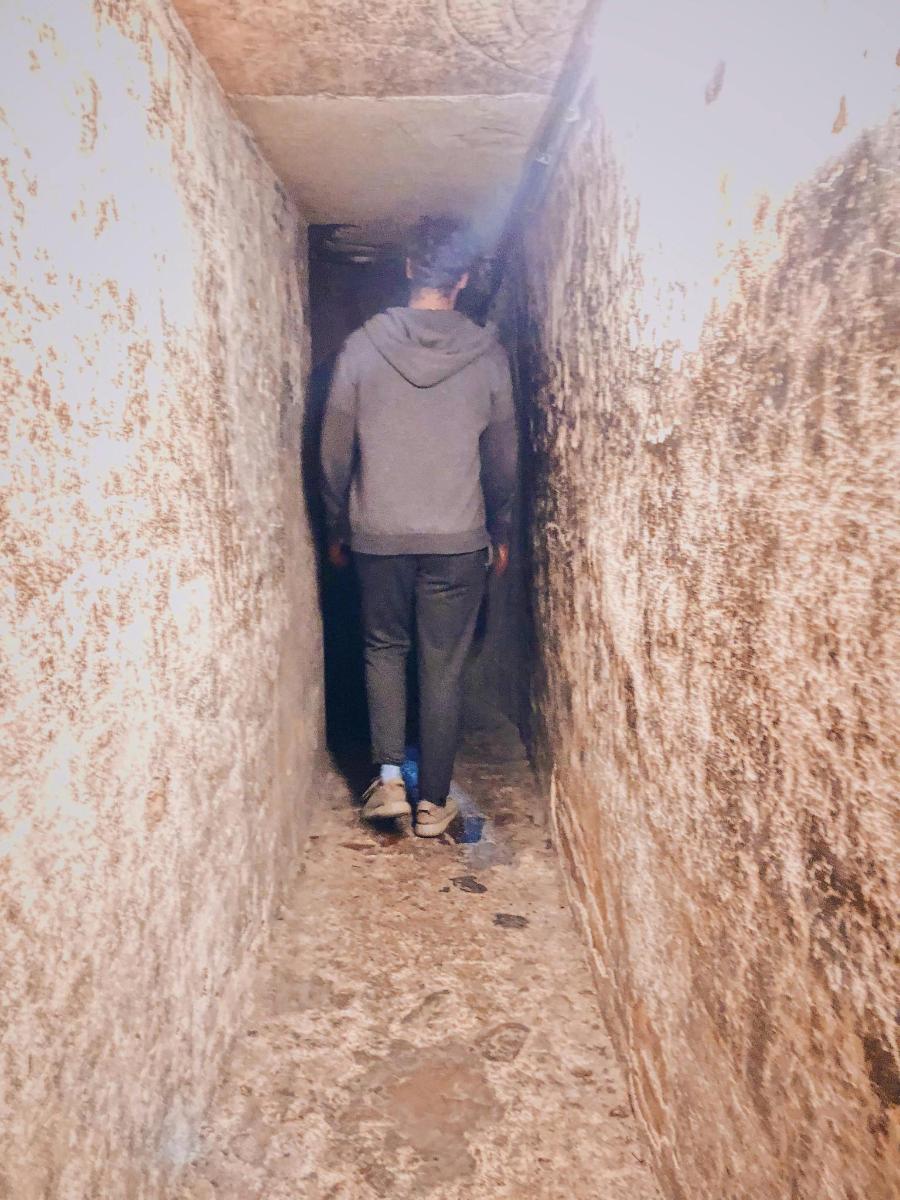 ein Mann, der eine dunkle Gasse entlanggeht