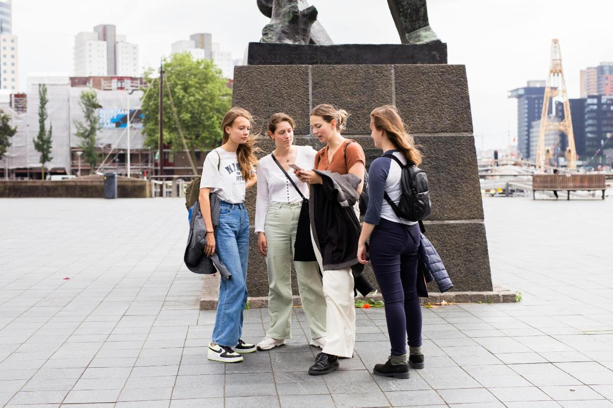 un gruppo di donne in piedi davanti a una statua