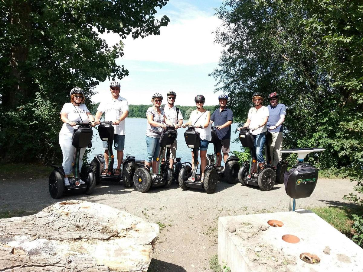 grupp inimesi sõidab segwaydel vee ääres