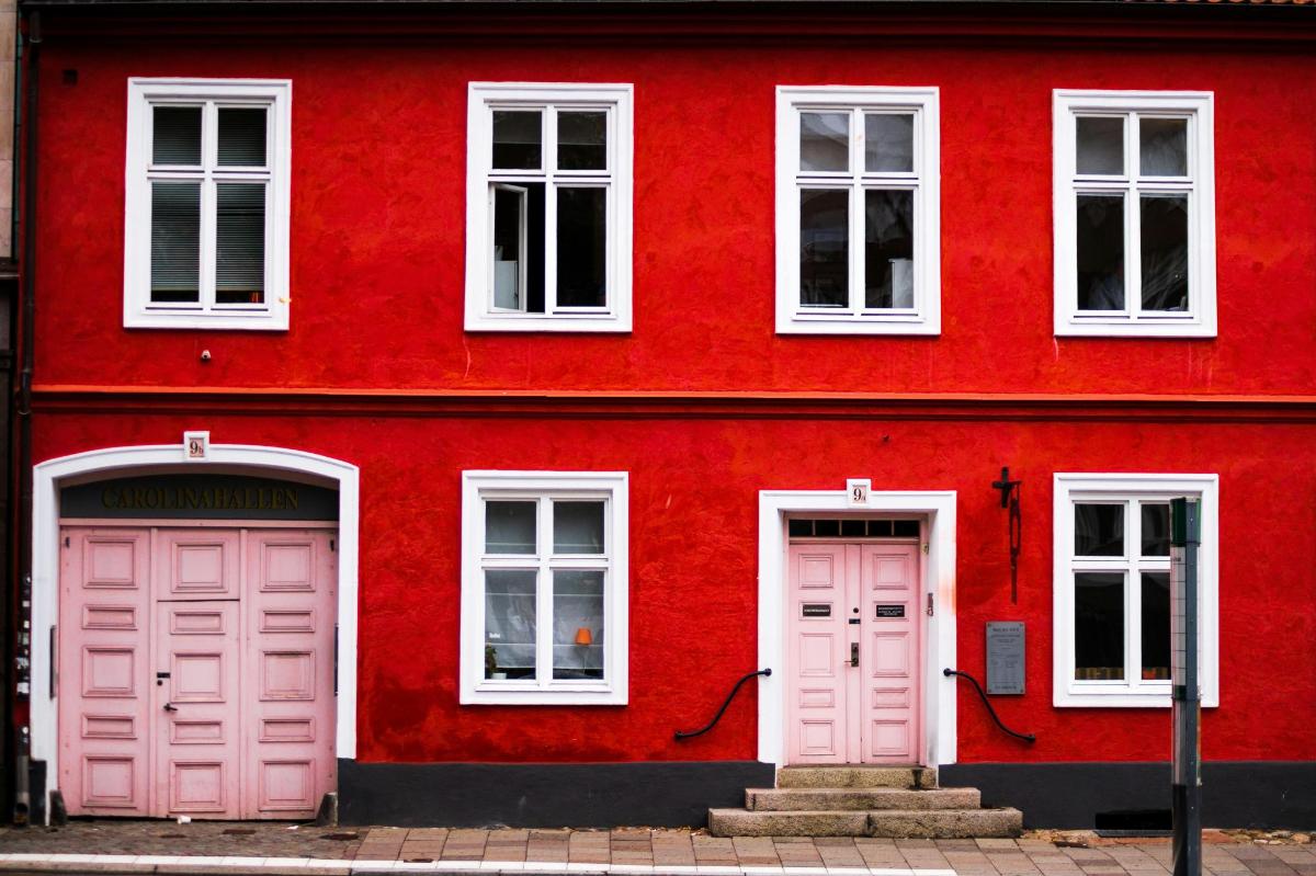 Un edificio rojo con dos puertas rosas.