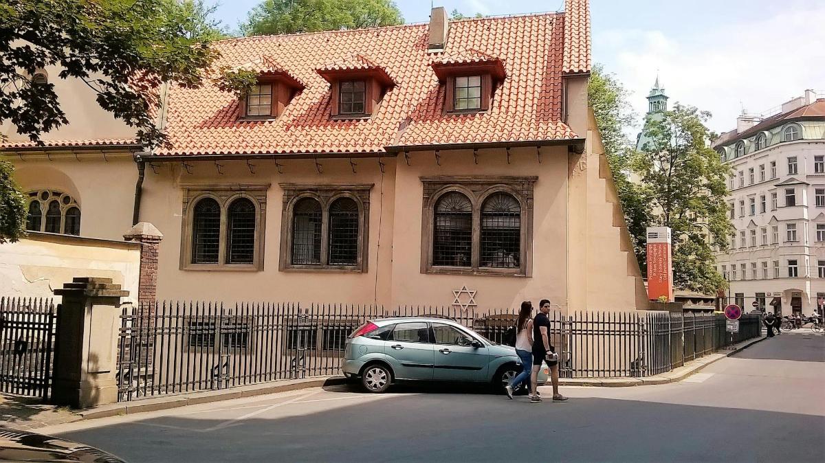 Μια γυναίκα που στέκεται δίπλα σε ένα μικρό αυτοκίνητο μπροστά από ένα κτίριο