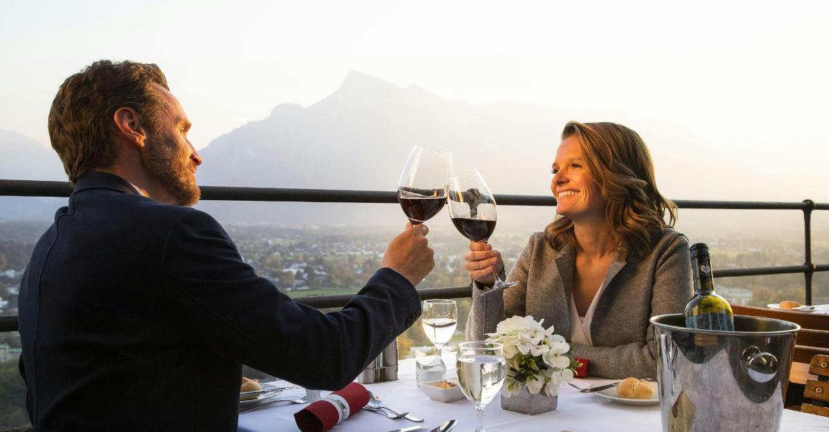 ein Mann und eine Frau sitzen mit Weingläsern an einem Tisch