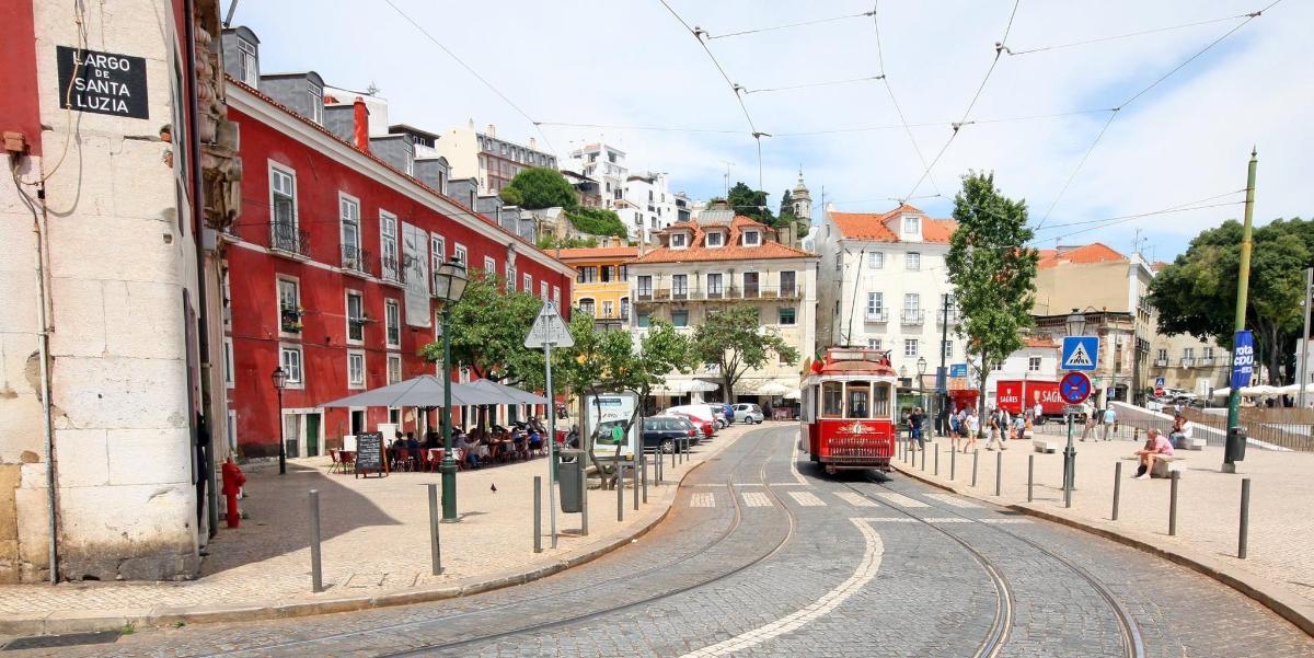 rdeč tramvaj na mestni ulici z zgradbami
