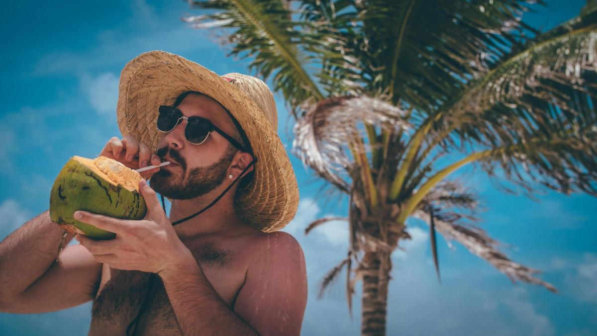 un bărbat cu o pălărie de paie mâncând o banană