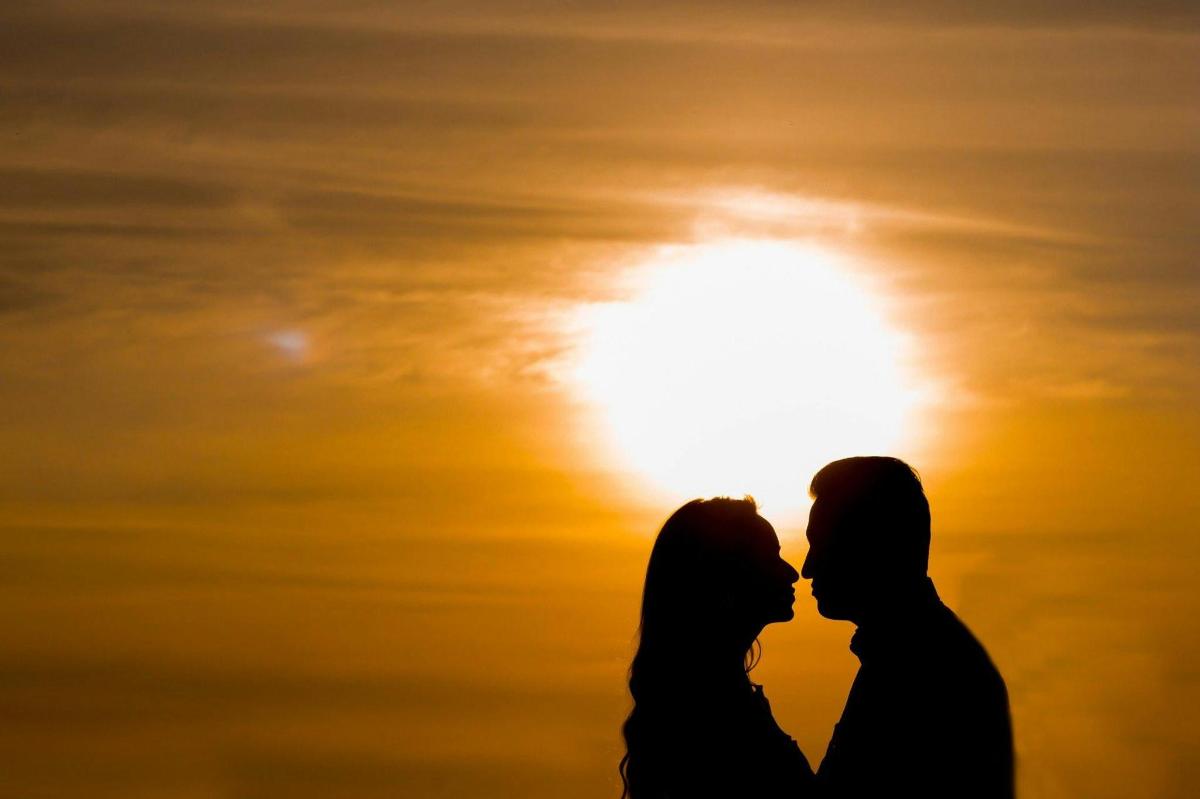 silueta d'una parella besant-se davant del sol