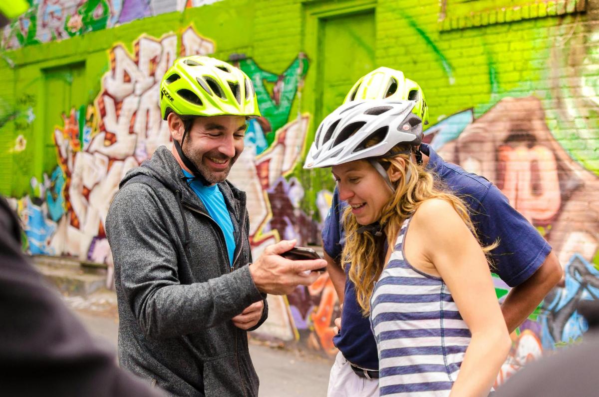 a man and woman wearing helmets looking at a cell phone
