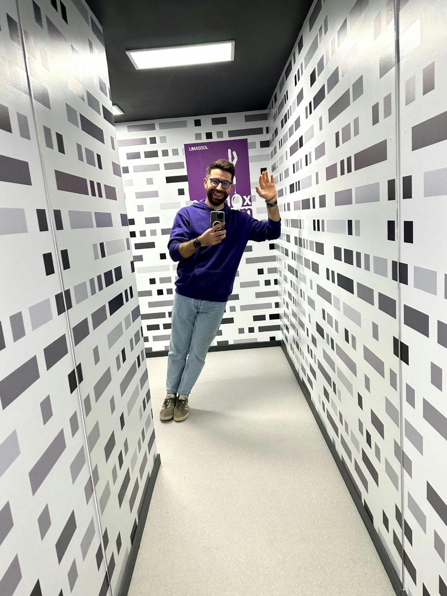 a man taking a picture in a room with white walls