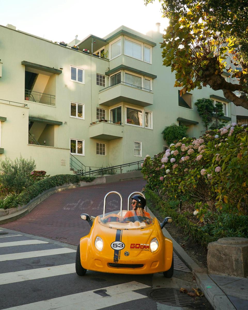 um carrinho de brinquedo laranja descendo uma rua