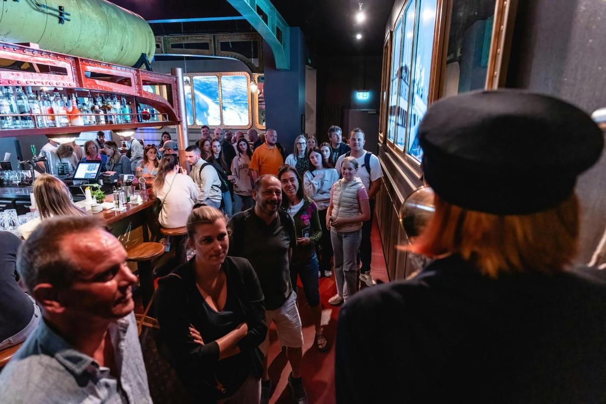 uma multidão de pessoas andando em volta de um bar
