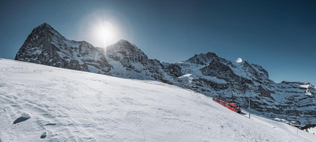 una montagna coperta di neve con il sole in cima