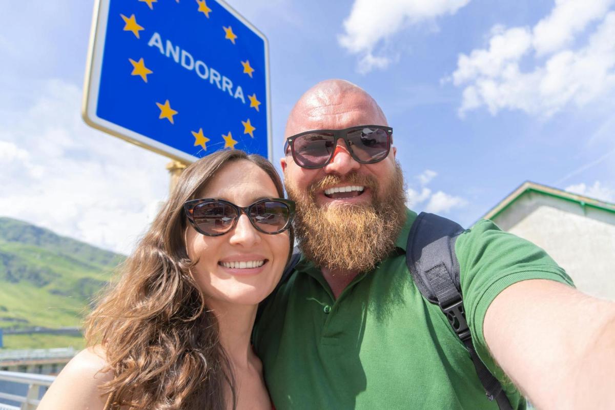 Un hombre y una mujer de pie junto a un cartel
