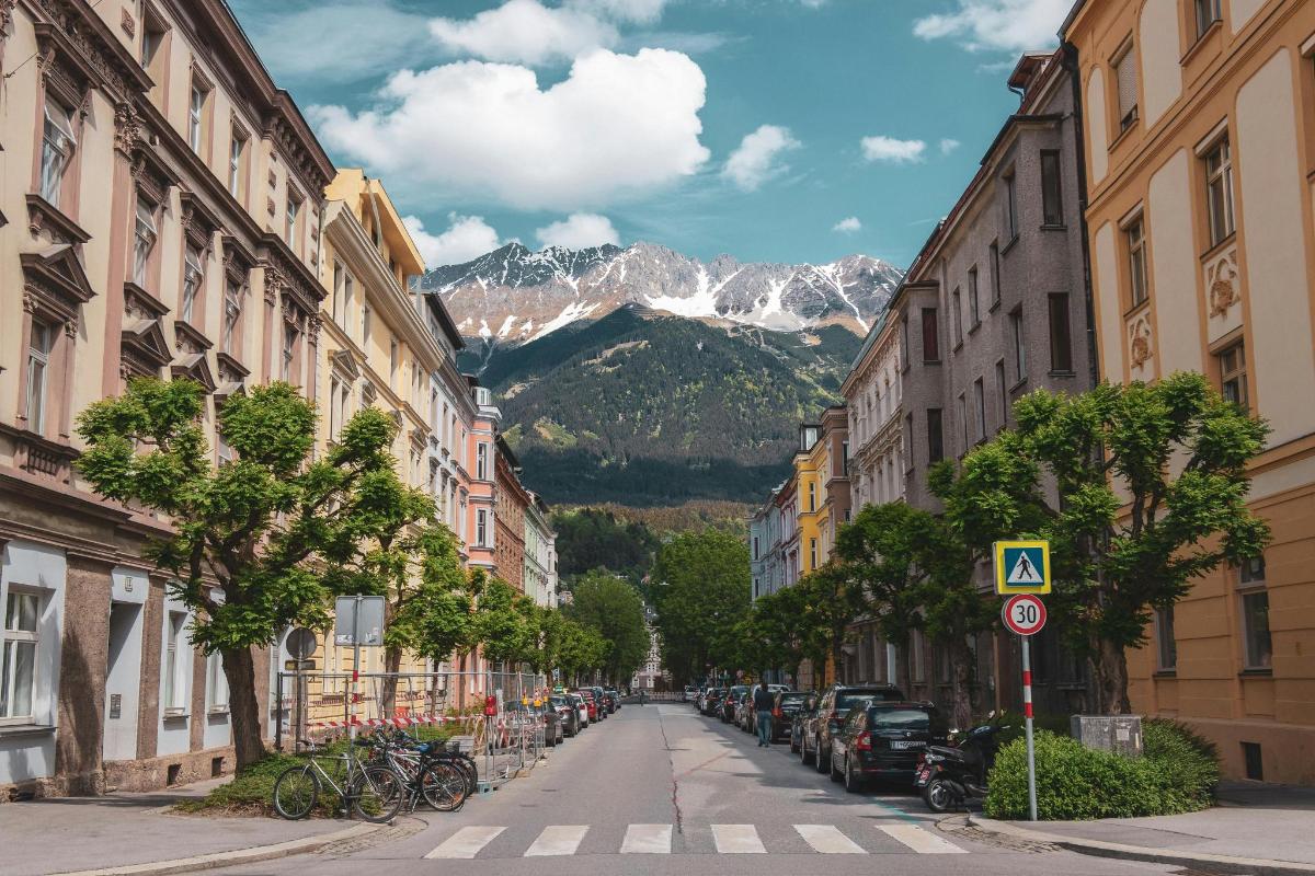 a city street with buildings and a mountain in the background