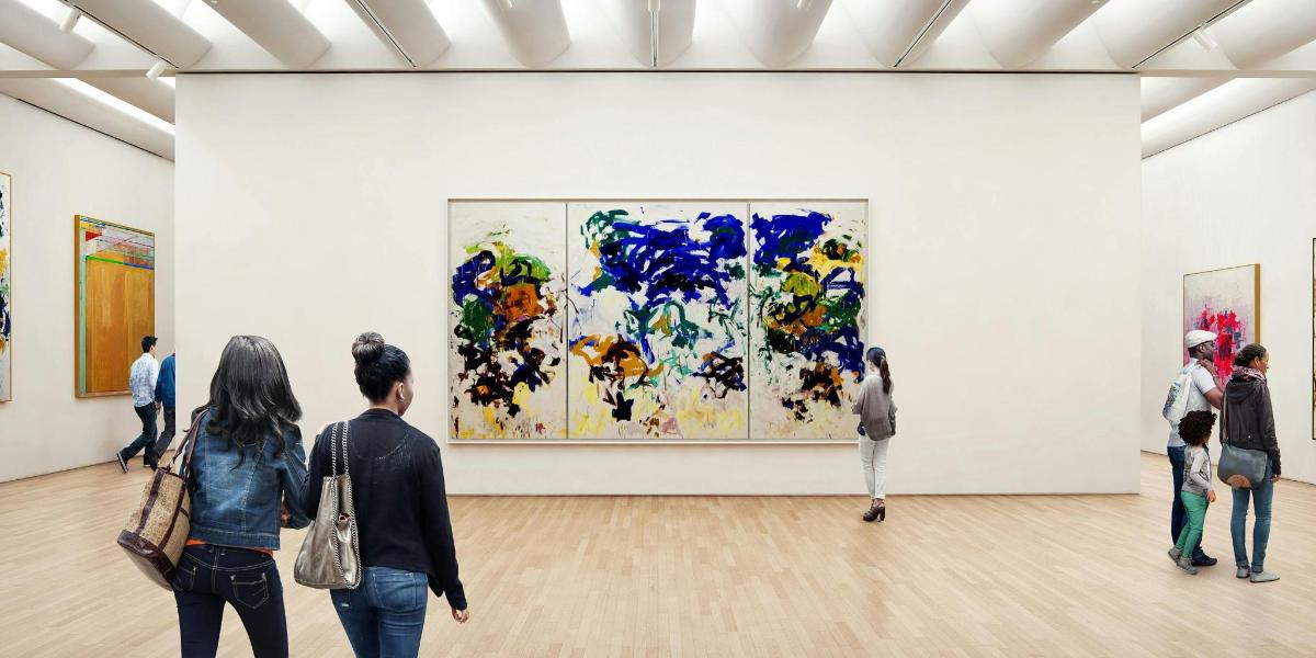 people looking at paintings in an art museum