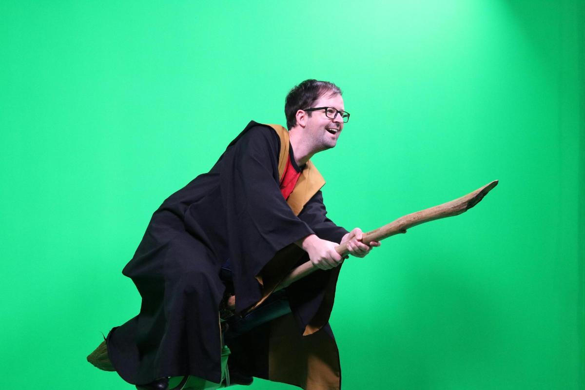 a man dressed as a wizard holding a wand