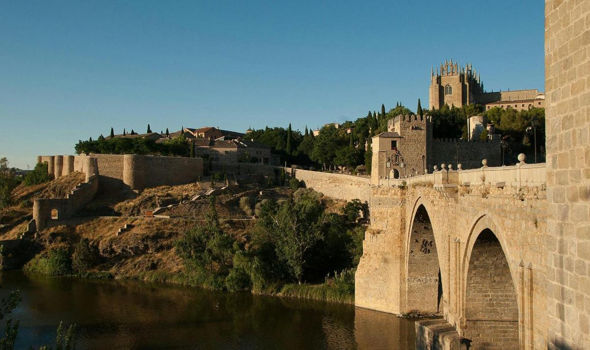 un ponte sopra un fiume con un castello sullo sfondo