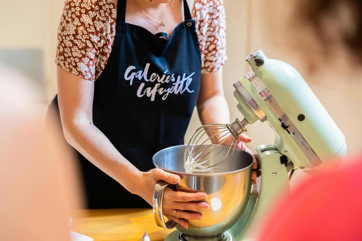 a woman in an apron is using a mixer