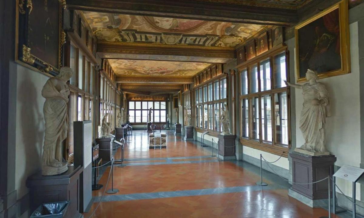 a hallway with statues in a building with windows